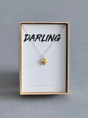 Gold heart necklace on a card with 'Darling' in a gift box.